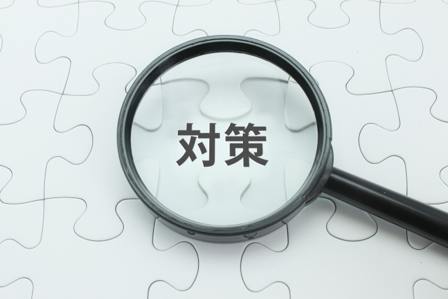 パズルの上に置かれた虫眼鏡と「対策」の文字