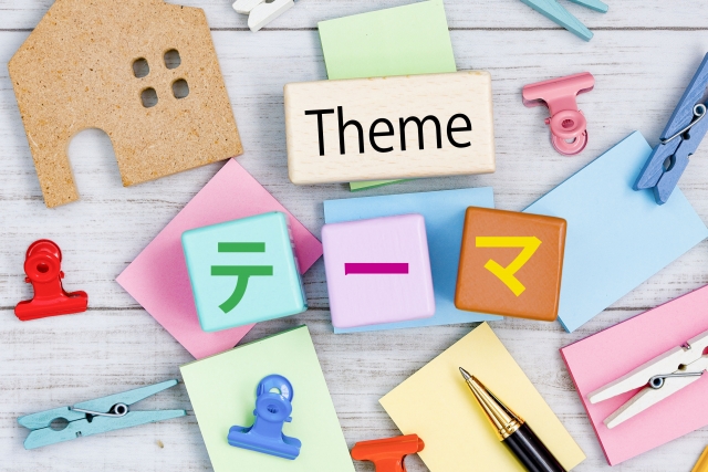 「Theme」と「テーマ」の文字が書かれた付箋と文房具